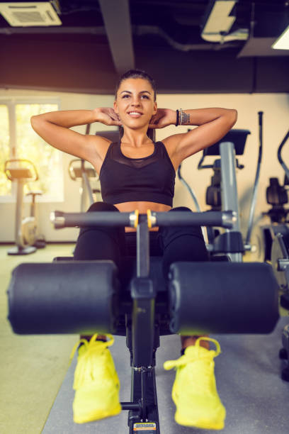 istock Attractive Young woman doing sit up exercise with machine at the gym. 1032694014