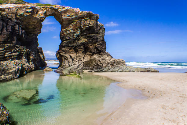 "Playa de las Catedrales" a magical place trying to fight against the Atlantic Ocean an amazing beach at North Spain in the community of Galicia Cathedrals Beach is an awesome and idyllic beach with amazing cliffs and formations similar to the Gothic Churches making it a magic place full of adventure galicia stock pictures, royalty-free photos & images