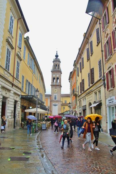people on via cavour in rainy weather, and convent of sao paolo. parma, italy. - circa 6th century imagens e fotografias de stock