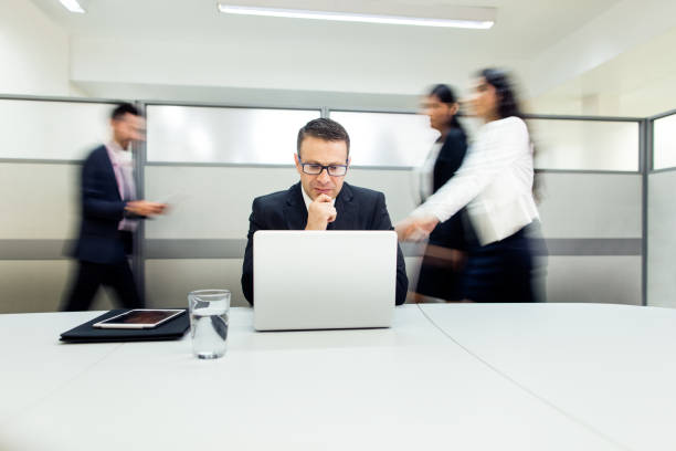 istock Male executive working on laptop in busy office 1032703162