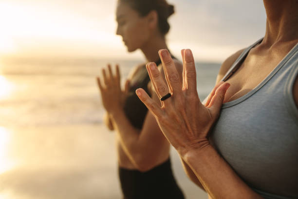 istock Women practicing yoga at the beach 1032706642