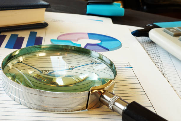 istock Magnifying glass on a business documents. Accounting and financial audit. 1032711018