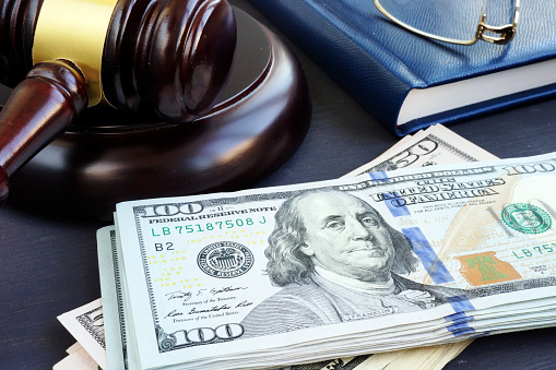 Litigation finance. Gavel and dollar banknotes. Bail bonds.