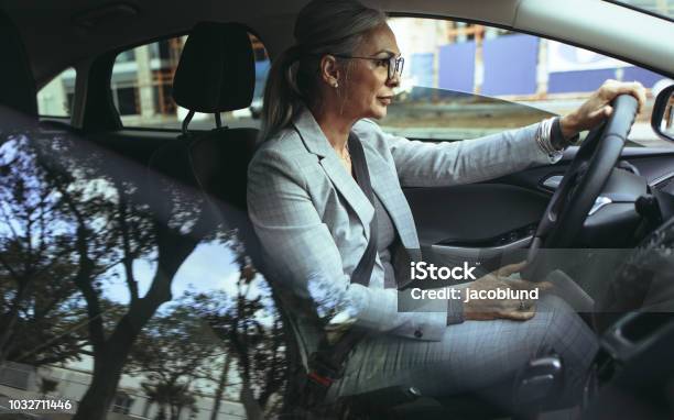 Empresaria Senior Conduce A La Oficina En Un Coche Foto de stock y más banco de imágenes de Conducir - Conducir, Coche, Mujeres