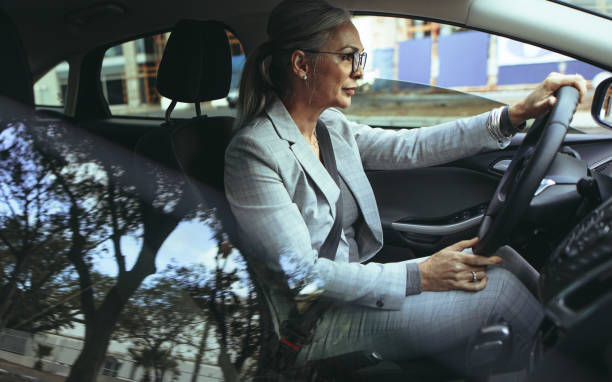 senior bizneswoman jazdy do biura w samochodzie - driving senior adult car women zdjęcia i obrazy z banku zdjęć