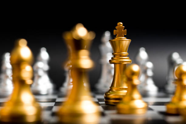 istock Gold king and team in chess game face with the another silver team on black background (Concept for company strategy, business victory or decision) 1032712008