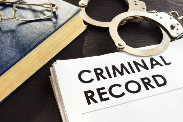 Criminal record and handcuffs on a desk. Criminal record and handcuffs on a desk. criminal stock pictures, royalty-free photos & images