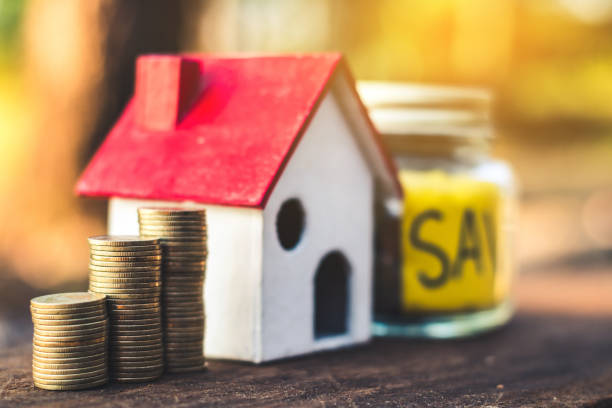 istock Close-Up Of Stacked Coins With Model Home On Table 1032713634