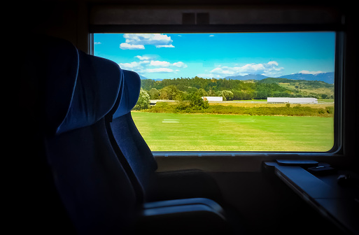Empty seats in a train moving through a countryside