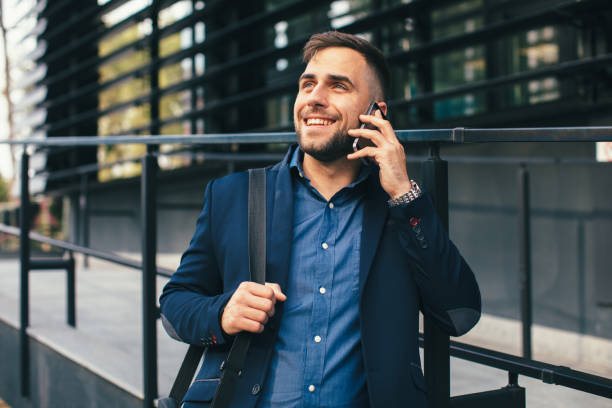 istock Handsome businessman talking on the phone leaning against the wall 1032716190