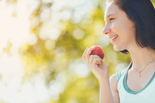 istock Smiling Woman Holding Apple 1032716470