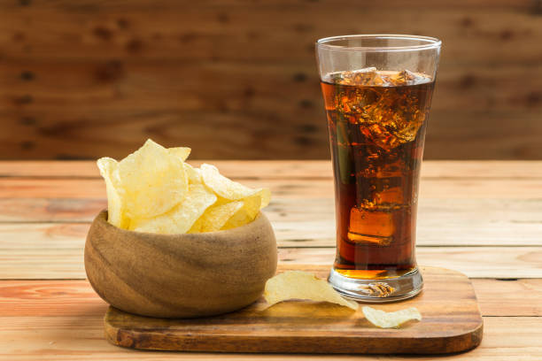 istock Potato chips with cola on a wooden background 1032717616
