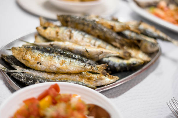 istock Delicious grilled sardines served with salad and potatoes 1032729376