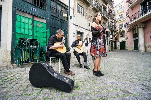 Paris, France - Oct. 2, 2023:  A street musician plays guitar for contributions at a sidewalk cafe in the Montmartre district.