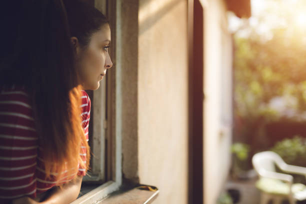 Young beautiful caucasian sad woman leaning on window sill.