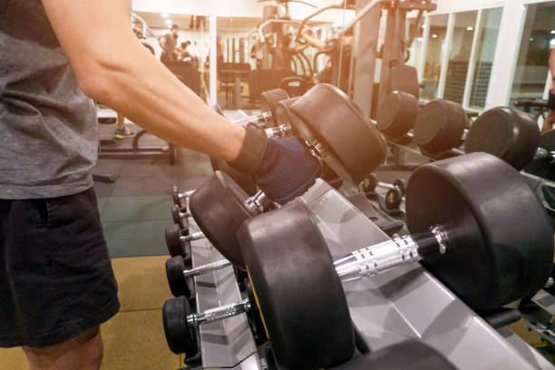 Human Hand holding dumbbell in gym