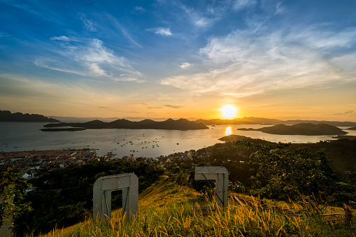 Palawan, Philippines - November 22, 2017: Palawan  view showing grasses, trees, mountains, houses, and river can be seen on the background in Coron area with a sunset