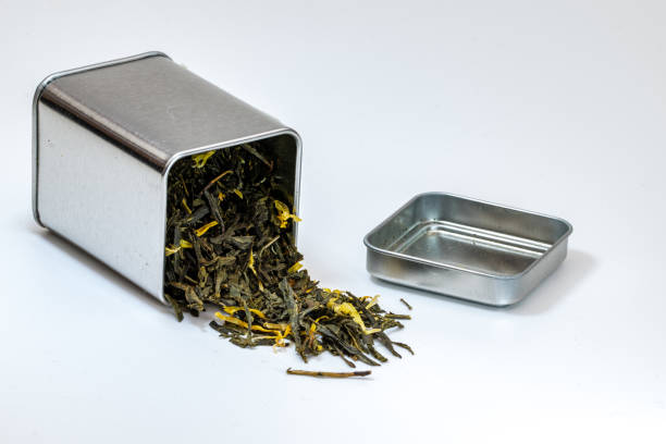 Dried green leaf tea in a small metal urn