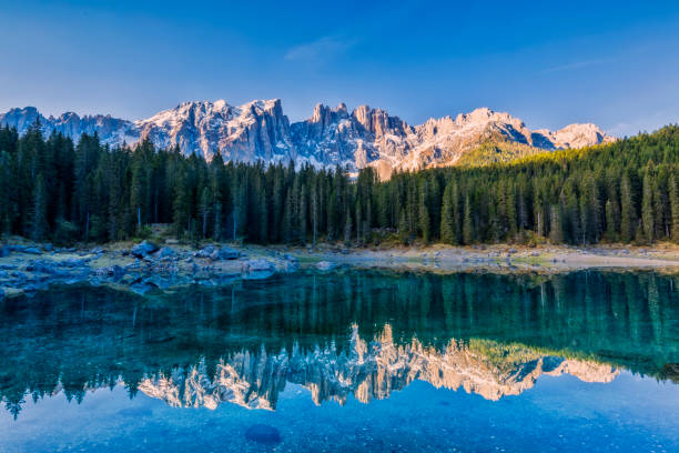 idyllic blue alpine lake carezza, dolomites, italian tirol alps - sunrise european alps mountain alpenglow imagens e fotografias de stock