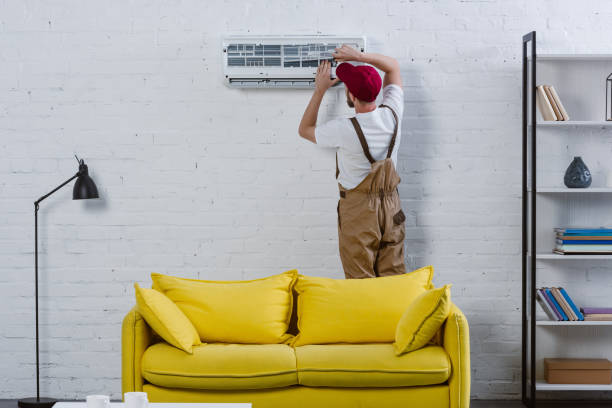 istock professional repairman fixing air conditioner hanging on white brick wall 1032763068