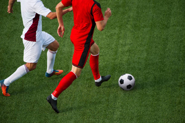 istock Low Section Of Soccer Players Playing On Field 1032782076