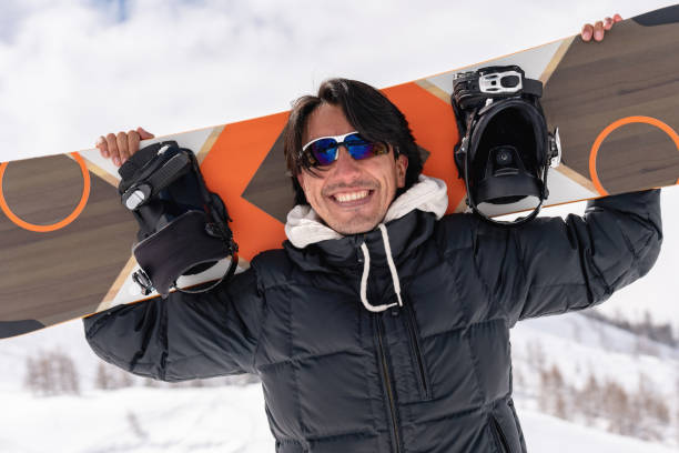 istock Portrait of a happy man snowboarding 1032798112