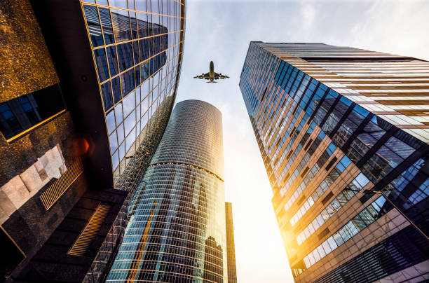 istock Futuristic office buildings with a airplane silhouette 1032799378