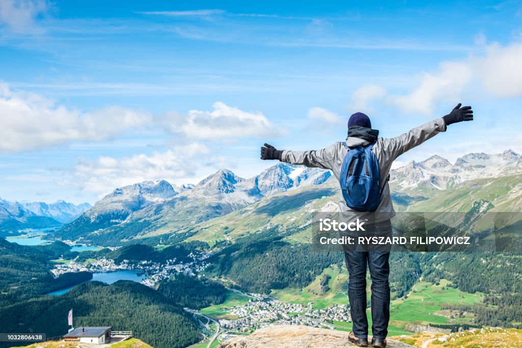 Young hiker standig front of the top of Piz da Staz and lakes in the area St.Moritz. Achievement Stock Photo