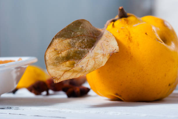 quince jelly and fruit on white wooden table background