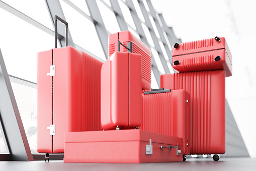 Stack of red suitcases of all sizes and forms standing on an airport floor near a large window. Concept of travelling for work and pleasure. 3d rendering mock up