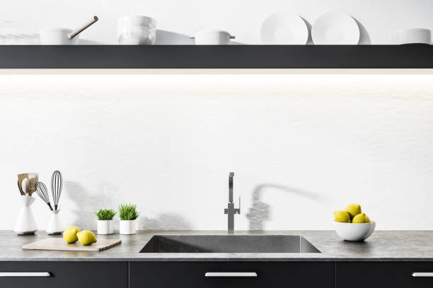 istock Black kitchen countertop in white room, sink 1032848388