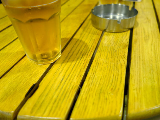 beer, cigarettes and telephone on wooden table