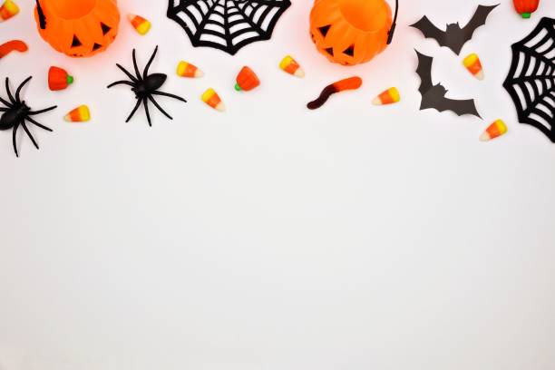 istock Halloween top border of candy and decor, flat lay over white 1032890436