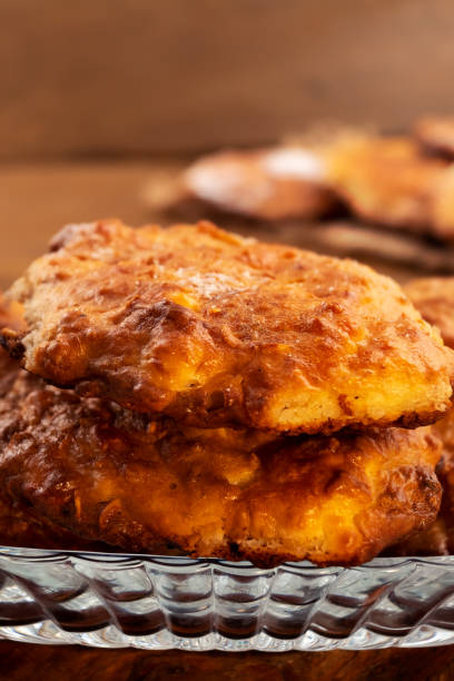 istock Round biscuits with a ruddy crust, stacked in a glass plate, close-up, vertical frame. 1032895720