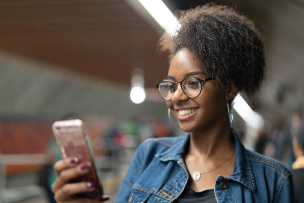 Young black woman using mobile in the subway