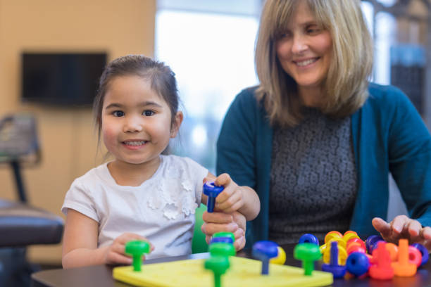 istock Occupational therapist works with a young ethnic girl 1032931010