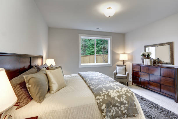 istock Light modern master bedroom interior with darkwood bed and dresser 1032935772