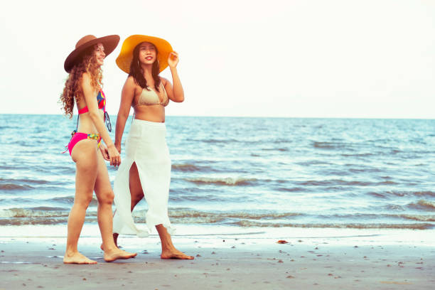 istock Happy women go sunbathing at sand beach in summer. 1032940838
