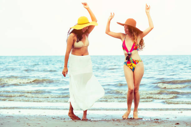istock Happy women dance on sand beach in summer. 1032940878