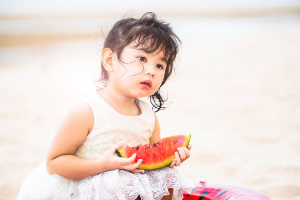 istock Adorable kid eating watermelon on the beach. 1032940932