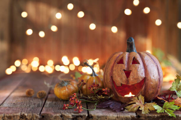 halloween-kürbis gegen einen alten holz-hintergrund - herbst kerzen stock-fotos und bilder