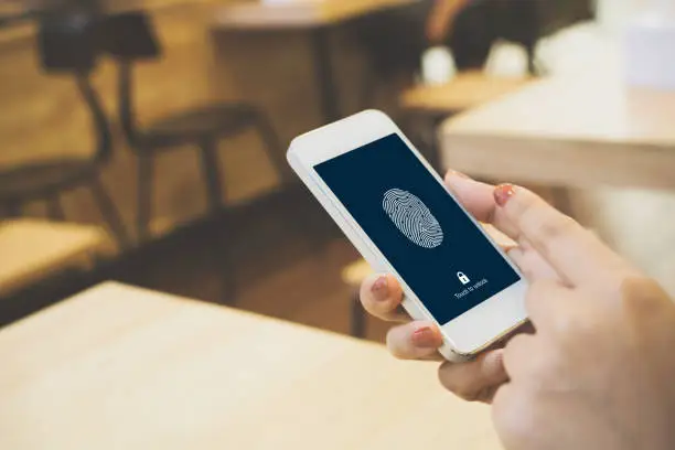 Photo of Hand women holding smartphone and scan fingerprint biometric identity for unlock her mobile phone