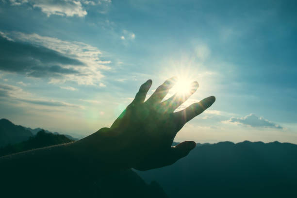 istock Hand stretched to rays of sun 1032990008