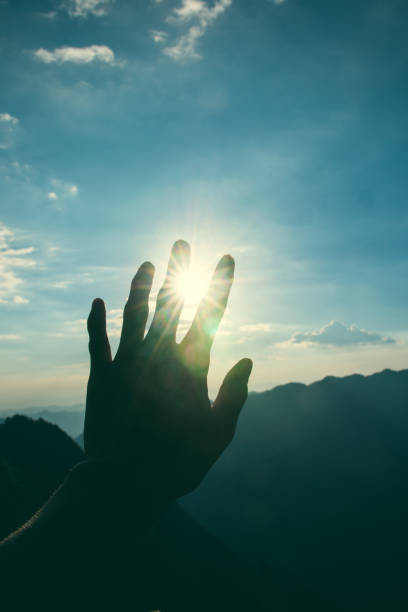 istock Hand stretched to rays of sun 1032990012