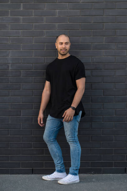 ritratto di uomo di razza mista maori/caucasico sicuro in jeans casual e abiti da maglietta contro un muro di mattoni neri in nuova zelanda, nuova zelanda - minority white simplicity confidence foto e immagini stock