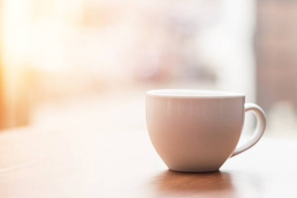 istock Coffee cup on wooden table in the morning with gold light feeling warm,Selective focus 1033010724
