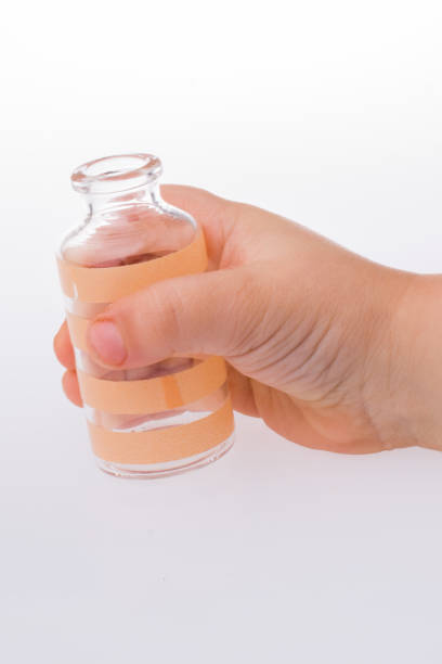 istock Little empty glass bottle in hand 1033034468