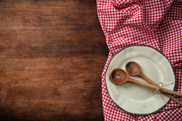 istock Empty plate, kitchen utensils and red tablecloth on wooden table, top view, copy space 1033034614