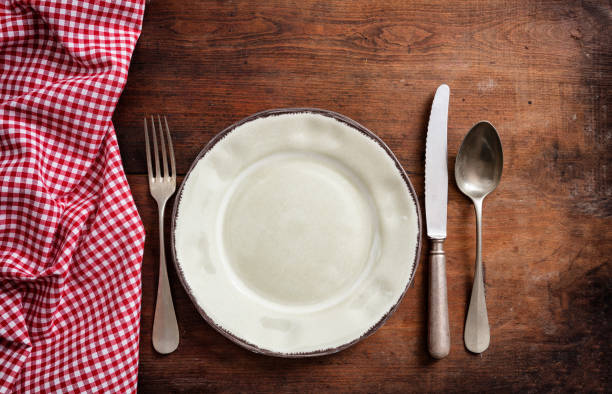 istock Traditional cutlery and plate, red checkered tablecloth on wooden table, top view 1033034616