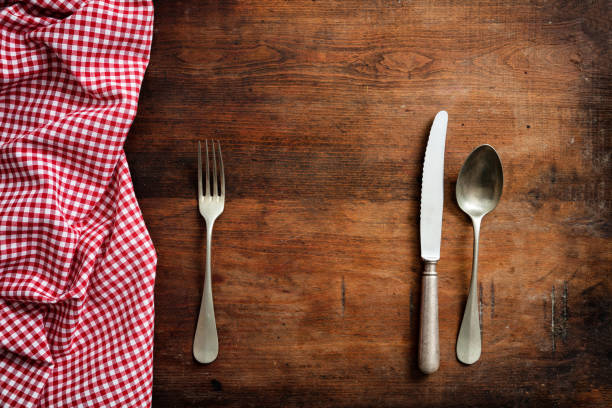 istock Wooden kitchen utensils on red checkered picnic tablecloth on wooden table, top view, copy space 1033034620